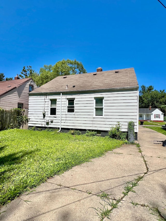 20244 Mccormick St, Detroit, MI 48224 - back of property featuring a shingled roof and a chimney