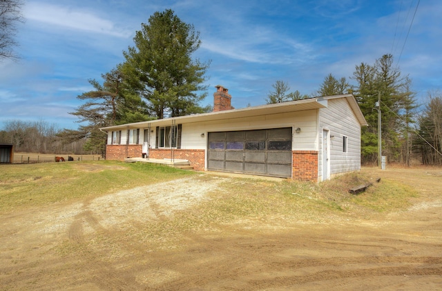 4650 Waltan Rd, Vassar, MI 48768 - ranch-style house with brick siding, a chimney, dirt driveway, and an attached garage