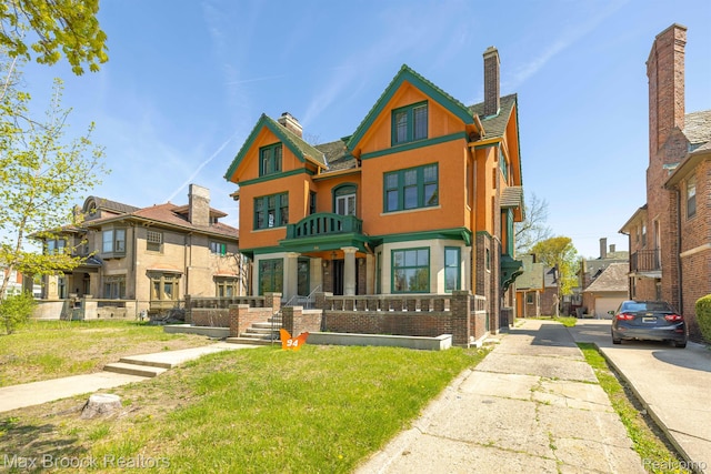 94 E Boston Blvd, Detroit, MI 48202 - view of front of house featuring a chimney, a residential view, a balcony, brick siding, and a front yard