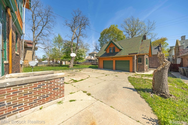 94 E Boston Blvd, Detroit, MI 48202 - view of side of home featuring a tile roof, an attached garage, concrete driveway, and brick siding