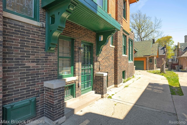 94 E Boston Blvd, Detroit, MI 48202 - doorway to property featuring brick siding, driveway, and a garage
