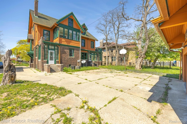 94 E Boston Blvd, Detroit, MI 48202 - rear view of house featuring a chimney, a shingled roof, and brick siding