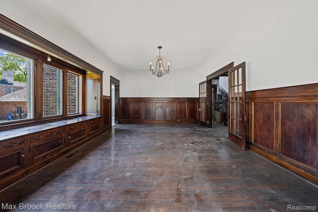 94 E Boston Blvd, Detroit, MI 48202 - unfurnished dining area featuring a chandelier, a wainscoted wall, and dark wood-style flooring