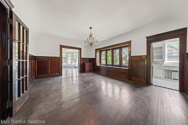 94 E Boston Blvd, Detroit, MI 48202 - unfurnished dining area featuring a wainscoted wall, dark wood-style floors, a chandelier, radiator, and a decorative wall