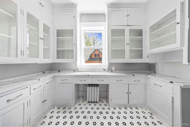 94 E Boston Blvd, Detroit, MI 48202 - kitchen with white cabinets, radiator heating unit, glass insert cabinets, and light stone counters