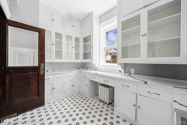 94 E Boston Blvd, Detroit, MI 48202 - kitchen featuring white cabinets, light stone counters, glass insert cabinets, and radiator heating unit