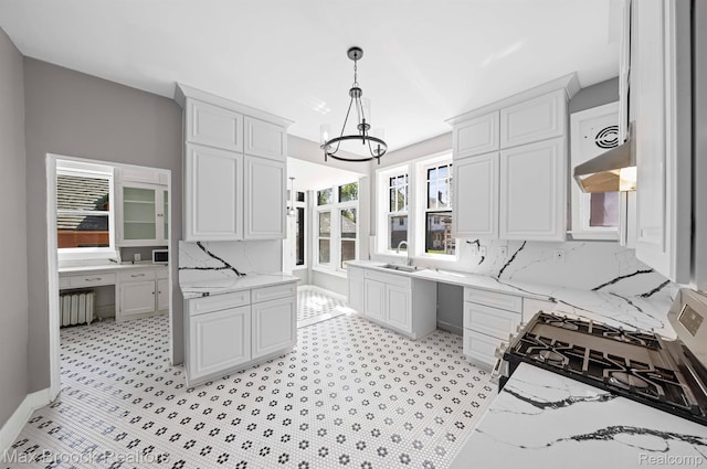 94 E Boston Blvd, Detroit, MI 48202 - kitchen with built in study area, a chandelier, radiator heating unit, under cabinet range hood, and stainless steel range with gas cooktop