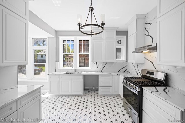 94 E Boston Blvd, Detroit, MI 48202 - kitchen with stainless steel gas range, under cabinet range hood, a chandelier, white cabinets, and light stone countertops