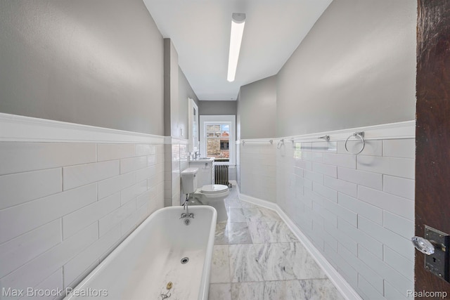 94 E Boston Blvd, Detroit, MI 48202 - bathroom featuring tile walls, a tub to relax in, wainscoting, radiator heating unit, and marble finish flooring