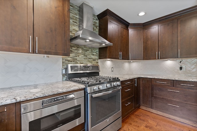 1533 Walton Blvd, Rochester Hills, MI 48309 - kitchen with wall chimney exhaust hood, stainless steel range with gas stovetop, built in microwave, light wood-type flooring, and light stone counters