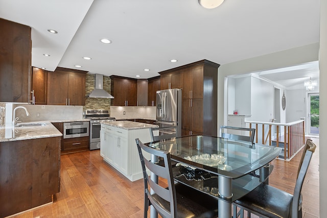 1533 Walton Blvd, Rochester Hills, MI 48309 - kitchen featuring stainless steel appliances, wall chimney range hood, a sink, a center island, and light wood-style floors