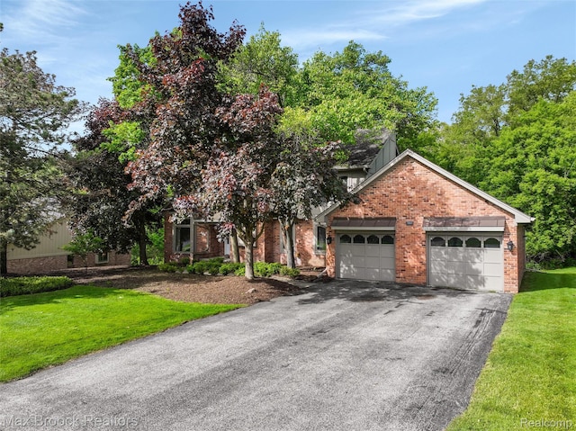 5844 Independence Ln, West Bloomfield, MI 48322 - view of front of home featuring asphalt driveway, an attached garage, brick siding, and a front yard