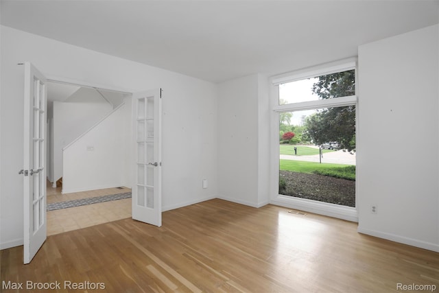 5844 Independence Ln, West Bloomfield, MI 48322 - spare room with french doors, light wood-style flooring, and baseboards