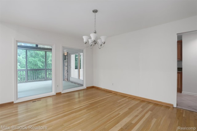 5844 Independence Ln, West Bloomfield, MI 48322 - empty room with a chandelier, light wood finished floors, and baseboards