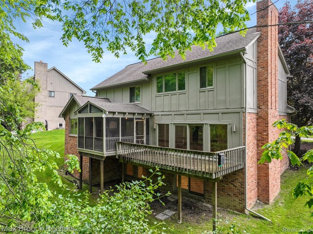 5844 Independence Ln, West Bloomfield, MI 48322 - rear view of house featuring a sunroom, board and batten siding, a chimney, and roof with shingles