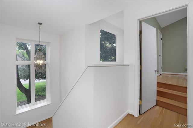 5844 Independence Ln, West Bloomfield, MI 48322 - hall featuring a chandelier, light wood finished floors, and baseboards
