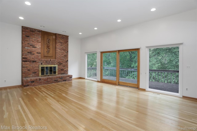 5844 Independence Ln, West Bloomfield, MI 48322 - unfurnished living room with light wood finished floors, recessed lighting, baseboards, and a brick fireplace
