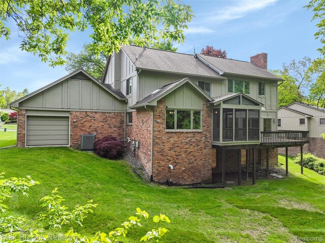 5844 Independence Ln, West Bloomfield, MI 48322 - back of property with a chimney, a sunroom, and a lawn