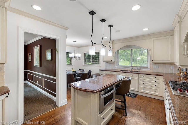 4889 Ardmore Dr, Bloomfield Hills, MI 48302 - kitchen featuring stainless steel appliances, dark wood finished floors, a kitchen island, hanging light fixtures, and crown molding