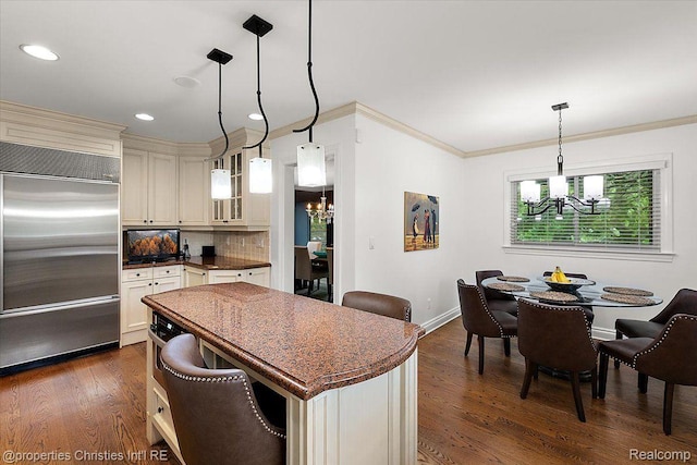4889 Ardmore Dr, Bloomfield Hills, MI 48302 - kitchen featuring built in fridge, a chandelier, dark countertops, glass insert cabinets, and crown molding