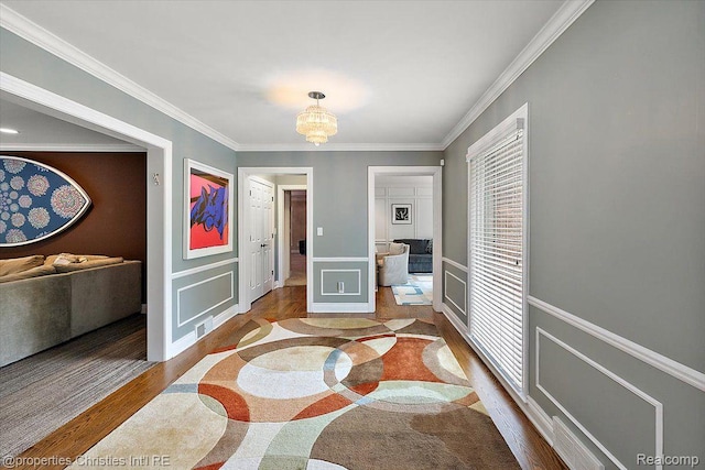 4889 Ardmore Dr, Bloomfield Hills, MI 48302 - hallway with wood finished floors, ornamental molding, a chandelier, a decorative wall, and inlaid floor details