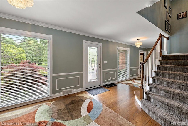 4889 Ardmore Dr, Bloomfield Hills, MI 48302 - entryway featuring plenty of natural light, crown molding, wood finished floors, stairway, and a chandelier