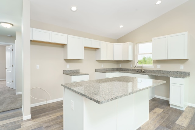 9674 Iosco Ridge Dr, Gregory, MI 48137 - kitchen featuring a sink, a kitchen island, lofted ceiling, white cabinets, and light stone counters