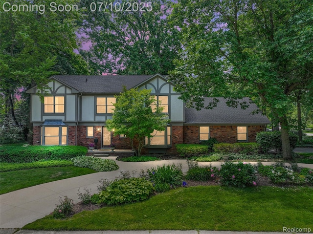 3445 Medford Dr, Troy, MI 48084 - tudor-style house with stucco siding, brick siding, a front yard, and a shingled roof