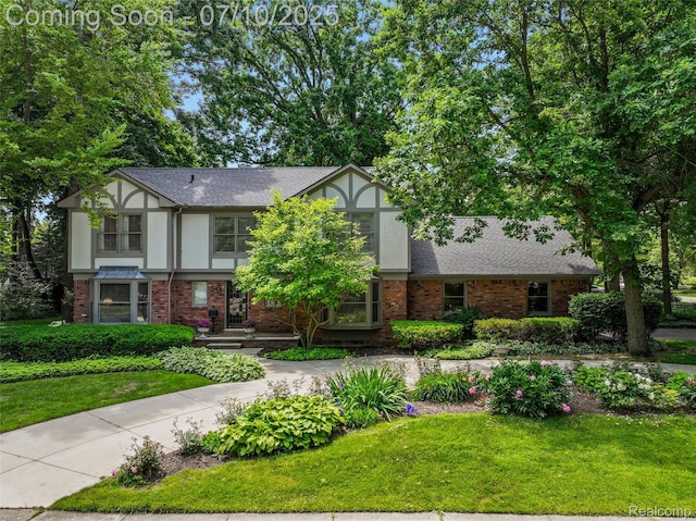 3445 Medford Dr, Troy, MI 48084 - tudor house with brick siding, a front yard, stucco siding, and a shingled roof