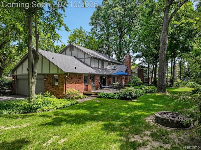 3445 Medford Dr, Troy, MI 48084 - rear view of property featuring a yard, a chimney, a wooden deck, an attached garage, and brick siding