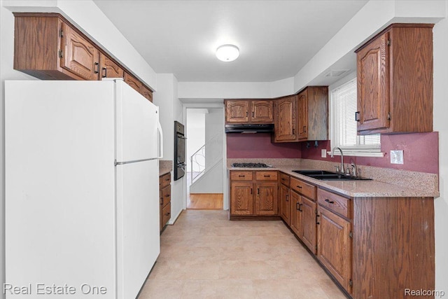 16917 Cicotte Ave, Allen Park, MI 48101 - kitchen featuring freestanding refrigerator, a sink, under cabinet range hood, oven, and gas stovetop