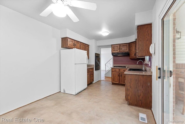 16917 Cicotte Ave, Allen Park, MI 48101 - kitchen featuring freestanding refrigerator, black oven, under cabinet range hood, a sink, and gas cooktop
