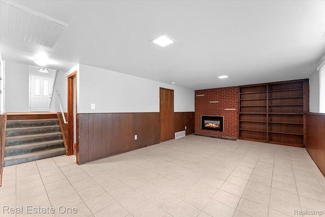 16917 Cicotte Ave, Allen Park, MI 48101 - unfurnished living room featuring wood walls, a wainscoted wall, built in shelves, stairs, and a fireplace