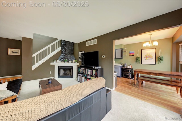 41381 Northwind Dr, Canton, MI 48188 - living room with light colored carpet, a chandelier, and light wood-style floors