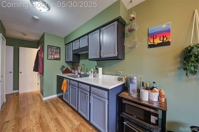 41381 Northwind Dr, Canton, MI 48188 - kitchen featuring a sink, light countertops, light wood finished floors, stainless steel microwave, and gray cabinets