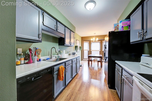 41381 Northwind Dr, Canton, MI 48188 - kitchen featuring dishwasher, a sink, light wood-type flooring, a chandelier, and light countertops