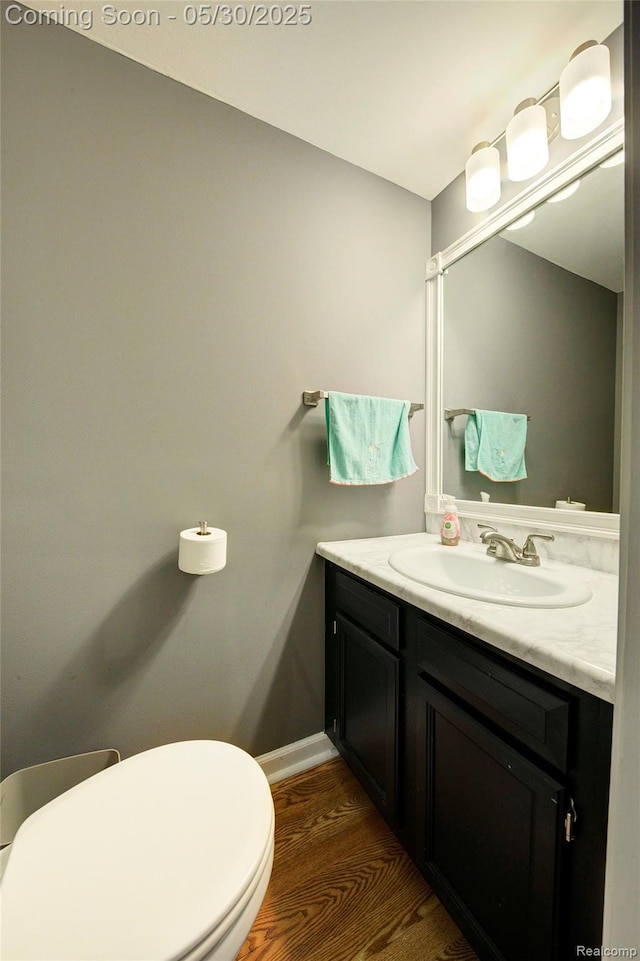 41381 Northwind Dr, Canton, MI 48188 - bathroom featuring vanity, wood finished floors, toilet, and baseboards