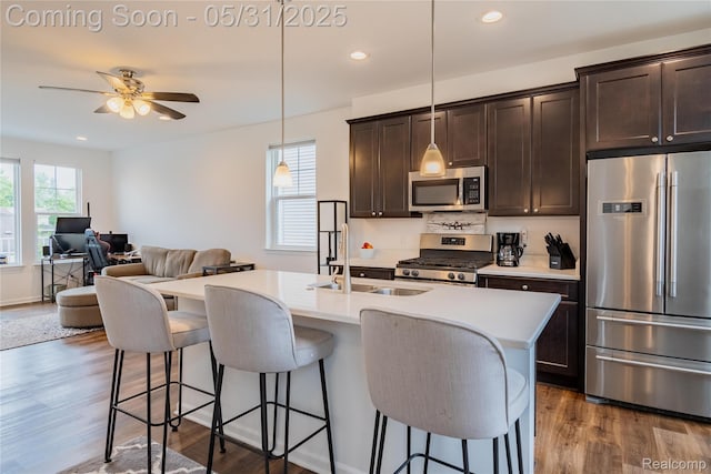 3217 Chambers W Unit 87, Wixom, MI 48393 - kitchen featuring stainless steel appliances, a kitchen breakfast bar, dark wood-style floors, ceiling fan, and dark brown cabinets