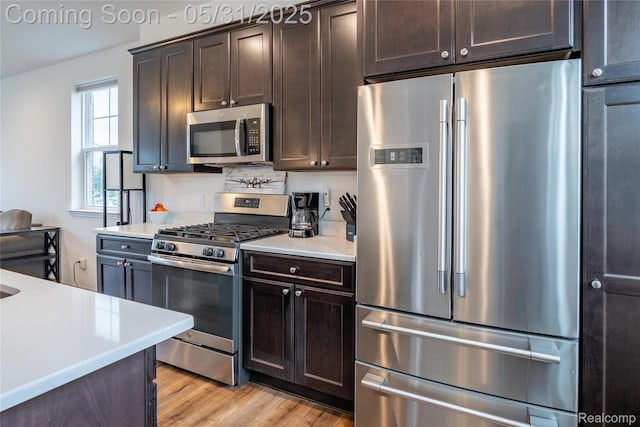 3217 Chambers W Unit 87, Wixom, MI 48393 - kitchen with stainless steel appliances, dark brown cabinetry, light countertops, and light wood-style floors