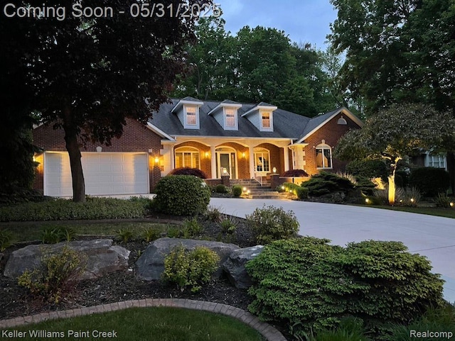 8241 Fountain View Dr, Flushing, MI 48433 - new england style home featuring covered porch, driveway, a garage, and brick siding