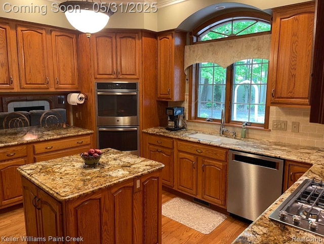 8241 Fountain View Dr, Flushing, MI 48433 - kitchen featuring stainless steel appliances, a sink, light stone countertops, and brown cabinets