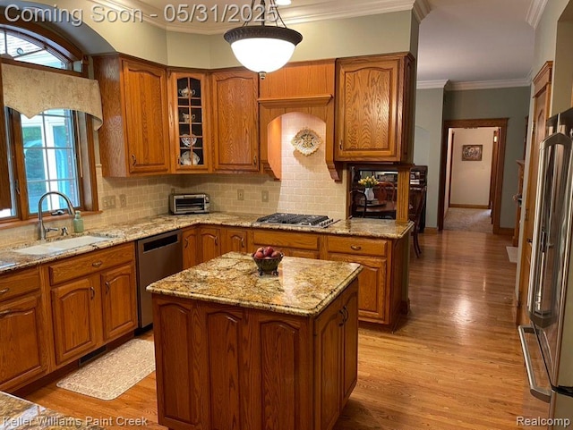8241 Fountain View Dr, Flushing, MI 48433 - kitchen featuring stainless steel appliances, a sink, brown cabinets, light wood-style flooring, and a kitchen island