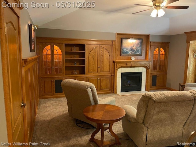 8241 Fountain View Dr, Flushing, MI 48433 - living room featuring light colored carpet, vaulted ceiling, a ceiling fan, and a tiled fireplace
