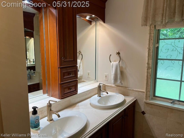 8241 Fountain View Dr, Flushing, MI 48433 - bathroom featuring double vanity, tile walls, and wainscoting