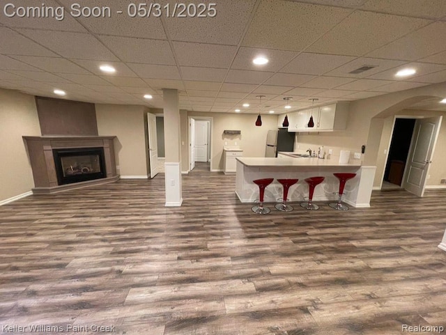 8241 Fountain View Dr, Flushing, MI 48433 - living room featuring dark wood-style floors, baseboards, recessed lighting, arched walkways, and a fireplace