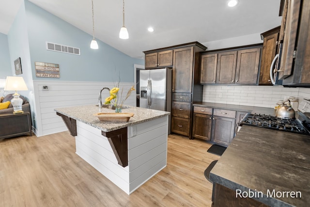 11648 Everette Ave, Allendale, MI 49401 - kitchen featuring dark brown cabinets, a sink, stainless steel appliances, a wainscoted wall, and lofted ceiling