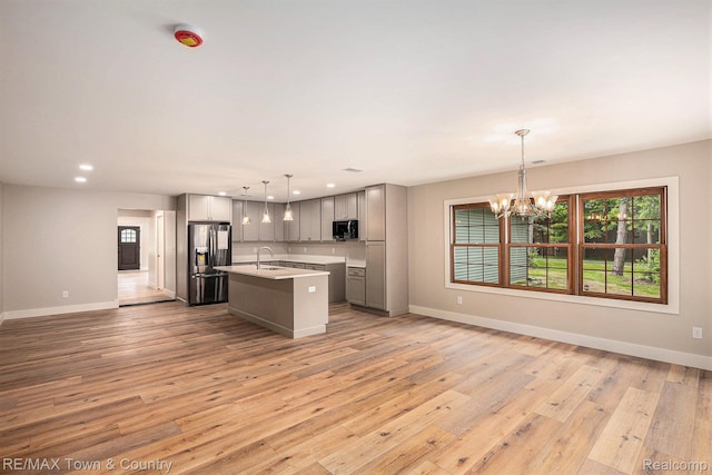 6400 N Seymour Rd, Flushing, MI 48433 - kitchen featuring stainless steel refrigerator with ice dispenser, a sink, black microwave, gray cabinets, and baseboards