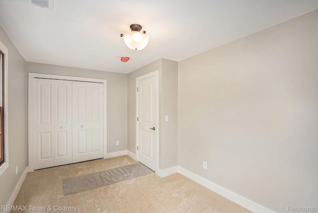 6400 N Seymour Rd, Flushing, MI 48433 - unfurnished bedroom featuring light colored carpet, baseboards, and a closet