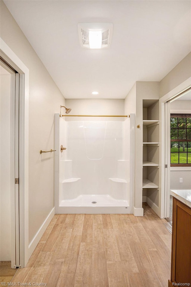 6400 N Seymour Rd, Flushing, MI 48433 - full bathroom featuring wood finished floors, a shower, baseboards, and vanity