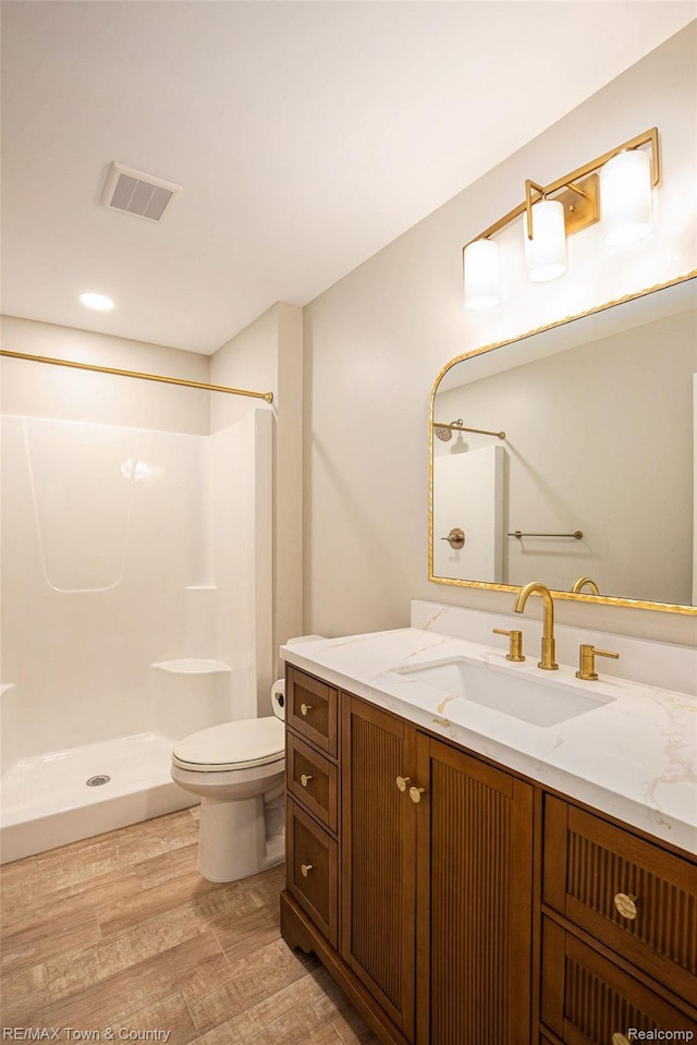6400 N Seymour Rd, Flushing, MI 48433 - full bath featuring toilet, vanity, a shower, wood finished floors, and recessed lighting
